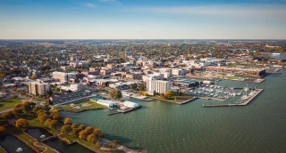 Boats sit idle docked to piers in a harbor along the coast just outside of downtown Sandusky, Ohio on a sunny autumn day.