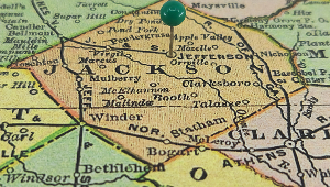 Jackson County marked by a green tack on a colorful vintage map – cheap car insurance in Georgia.