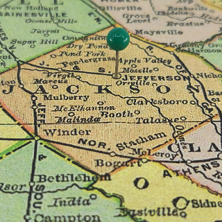Jackson County marked by a green tack on a colorful vintage map – cheap car insurance in Georgia.