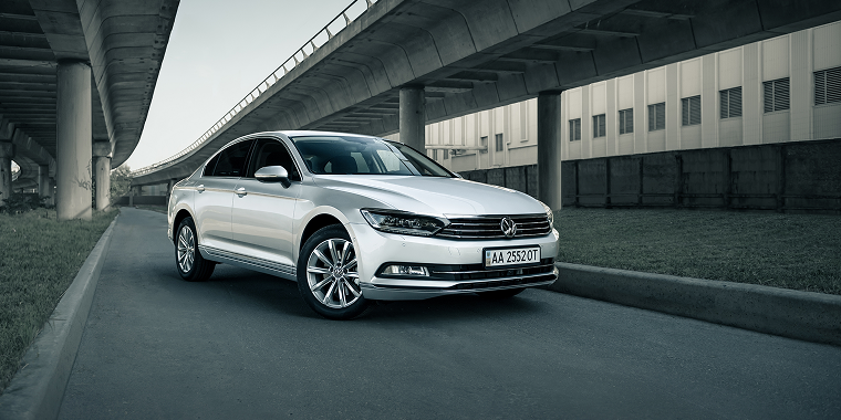 Silver Volkswagen CC under two bridges. Perspective front three quarter view of german sedan in urban setting. Kyiv, Ukraine, cheap car insurance.