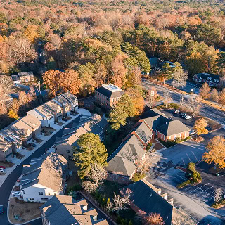 Aerial view of Johns Creek houses and townhomes shot during the fall at sunset