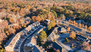 Aerial view of Johns Creek houses and townhomes shot during the fall at sunset