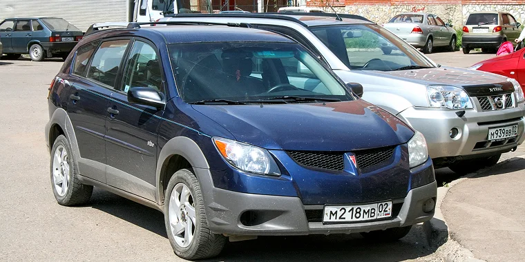 Motor car Pontiac Vibe in the city street. – cheap car insurance.