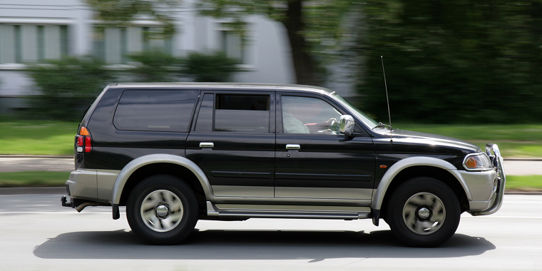 Black Mercury Mariner SUV speeding on a road covered with cheap car insurance from Freeway. Cheap car insurance.
