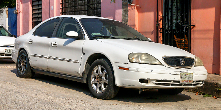 May 23, 2017: A white luxury Mercury Sable on a city street, covered by cheap car insurance.
