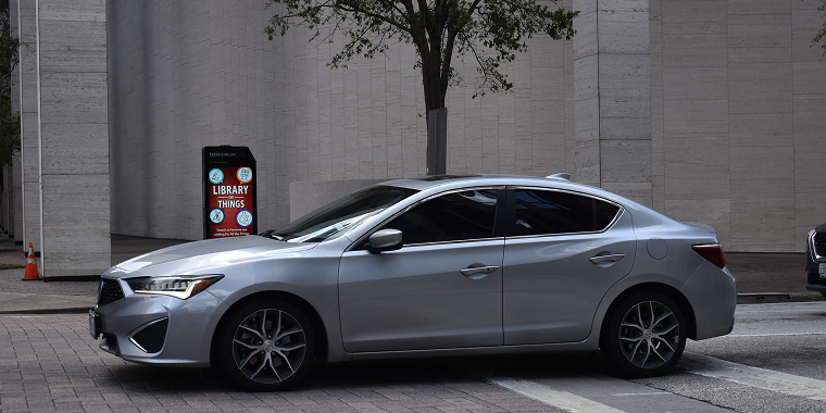 An Acura ILX premium luxury sedan, in the downtown metropolis of Houston — Cheap car insurance.
