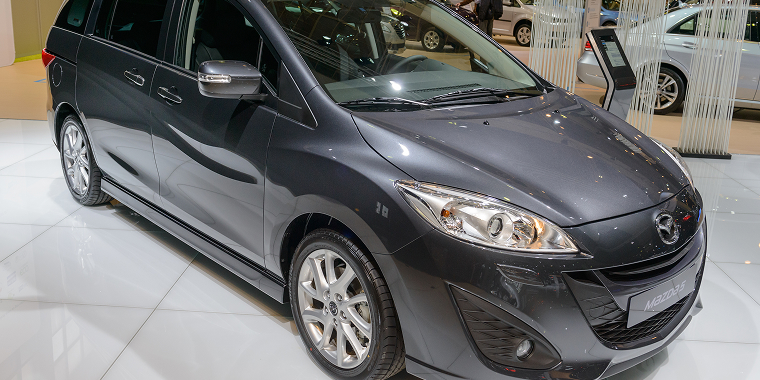 Mazda 5 MPV family car on display at the 2014 Brussels motor show. People in the background are looking at the cars – Mazda, cheap car insurance.