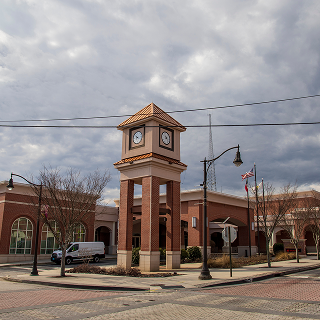 Douglasville, Georgia USA - 2 10 2023: The Douglasville Conference Center surrounded by bare winter trees, lush green plants and tall light posts with powerful clouds on Church Street in Douglasville.