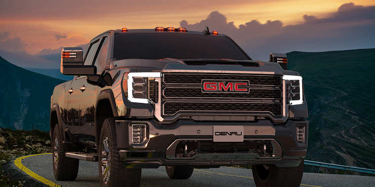 Black GMC Sierra HD Denali on a highway at sunset in Szczecin, Poland, October 2022. Cheap car insurance.