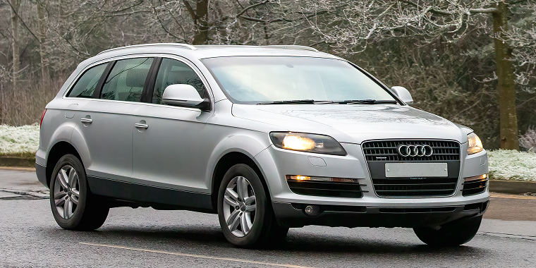 Audi Q7 diesel engine SUV car driving on a cold, frosty morning — Cheap car insurance.