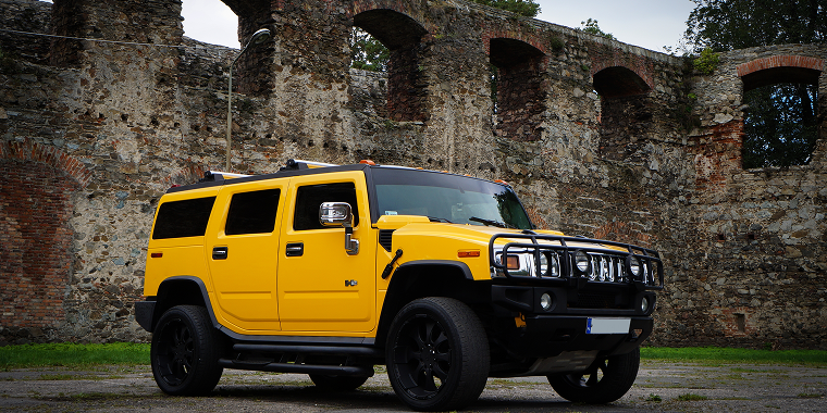 Classic Hummer H2 on the parking place with old Castle walls in the Background – Hummer, cheap car insurance.