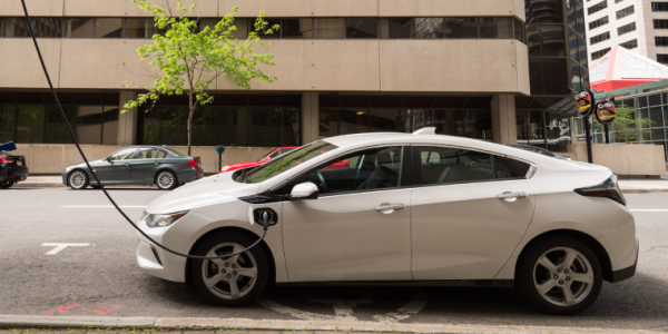 Chevrolet Volt electric car plugged into an EV charging station in Downtown Montreal. Cheap car insurance for Chevrolet.
