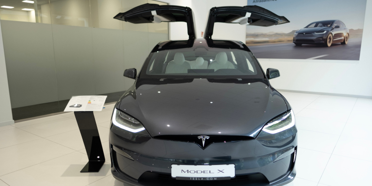 New grey Tesla Model X electric car in showroom, falcon-wing doors, trends EV in contemporary Europe, American company, electric vehicle production, Frankfurt, Germany - June 28, 2024. Cheap car insurance for Subaru.