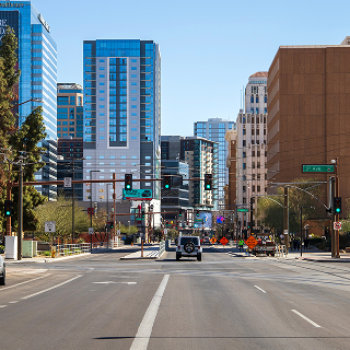 Skyscrapers and office buildings in the city skyline with cars on the street in downtown Phoenix Arizona USA.
