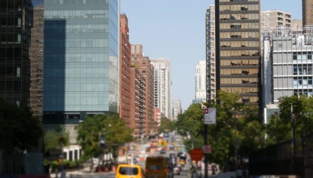 New York City street with traffic and high-rise buildings, highlighting the urban setting for New York car insurance requirements and coverage.