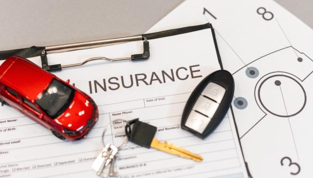 Car insurance form, keys, and a red toy car placed on paperwork, highlighting Texas Takes Worry Out of Producing Proof of Insurance.