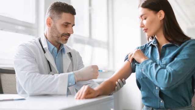 Doctor giving a vaccine to an adult patient in a clinic, representing vaccines as essential preventive healthcare