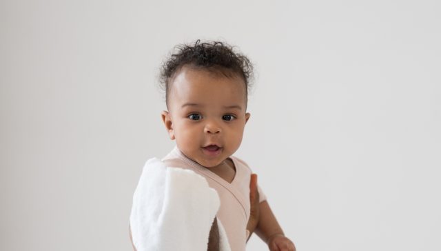 Smiling newborn baby, highlighting the importance of newborn health insurance enrollment.