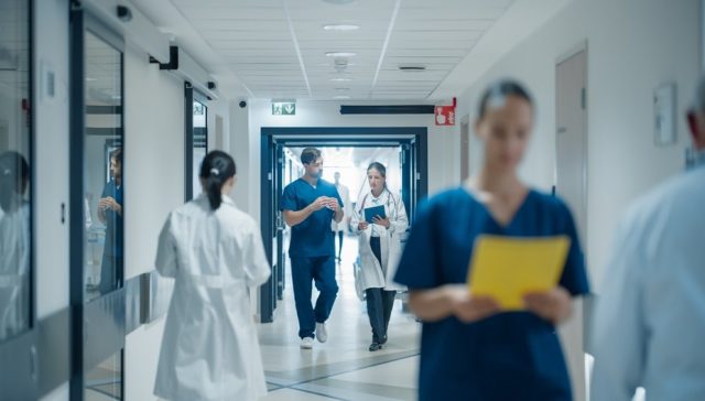 Healthcare professionals walking through a hospital hallway, representing healthcare options when switching Covered California plans.