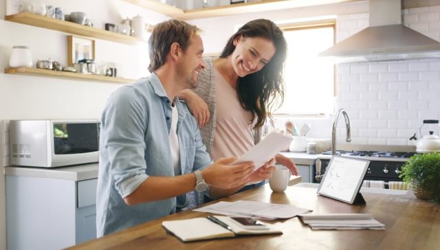 Couple reviewing paperwork at home, representing understanding what an escrow is during a real estate transaction.