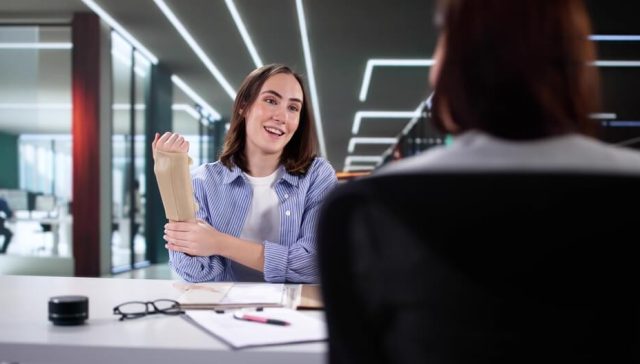 Woman with arm injury speaking to an agent, representing workers’ comp and general liability insurance coverage.