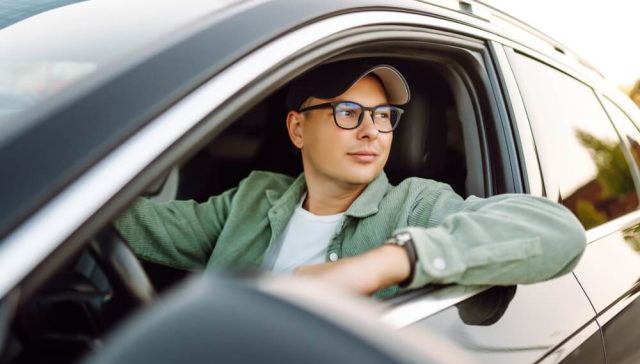 Driver behind the wheel of a car, illustrating how car subscription services affect insurance coverage.