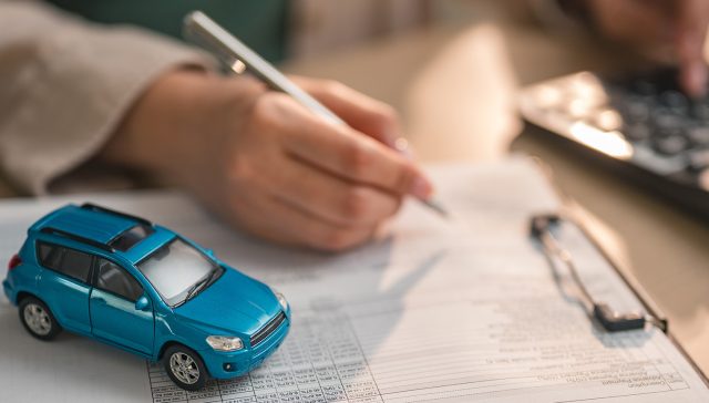 Miniature car on insurance documents