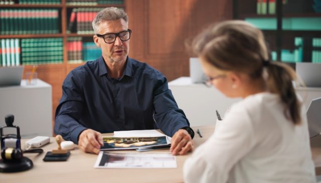 Homeowner meeting with an insurance agent to discuss home insurance quotes.